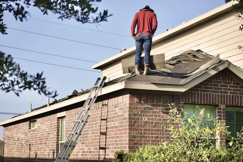 Professional roofer working on a residential roof in Madsen
